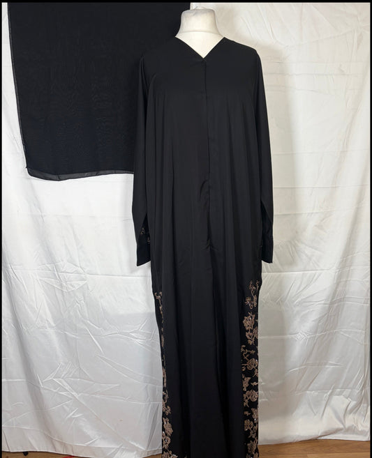 Black dress with floral details on a white fabric backdrop