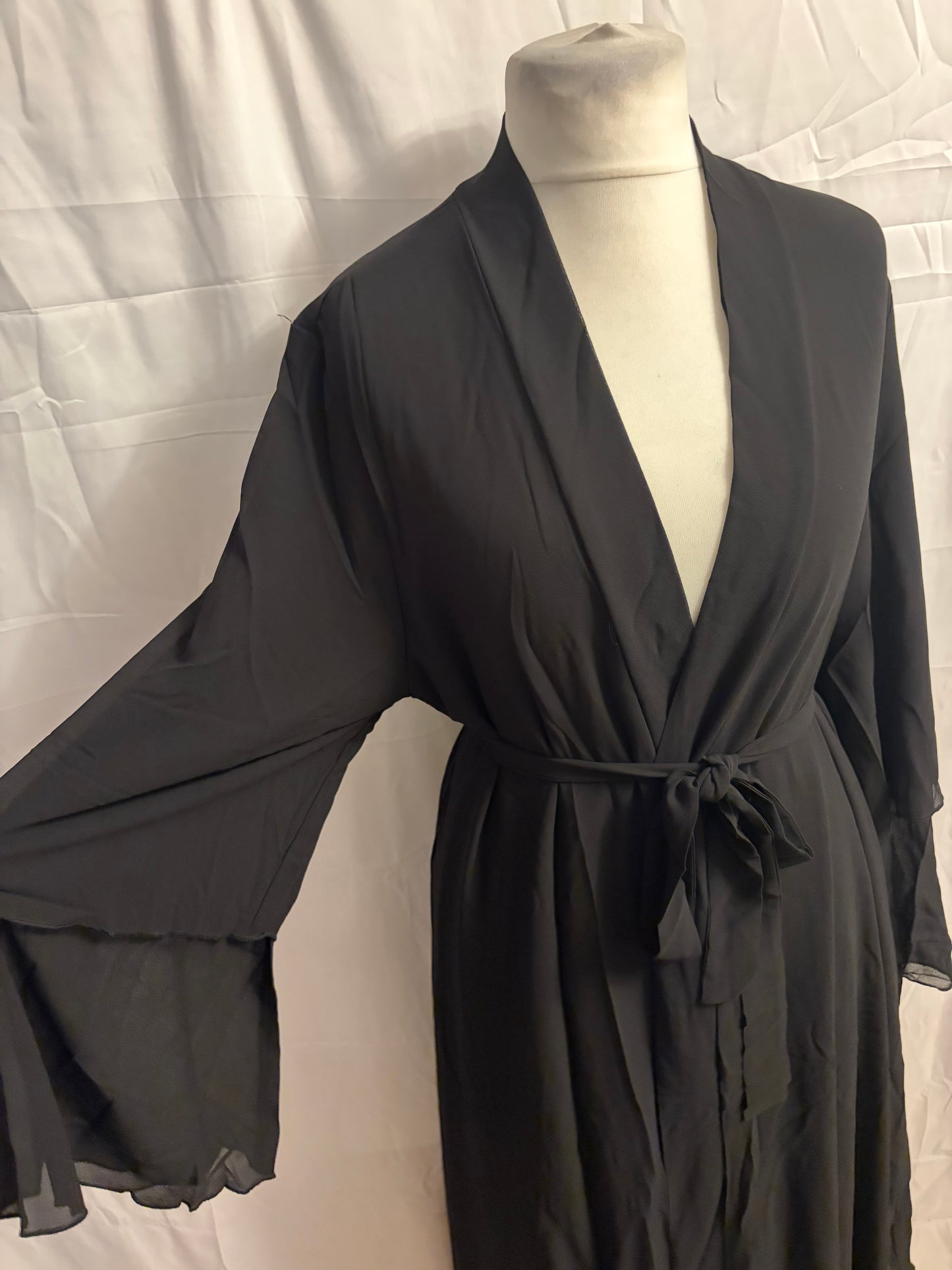 Black abaya on a mannequin against a white background