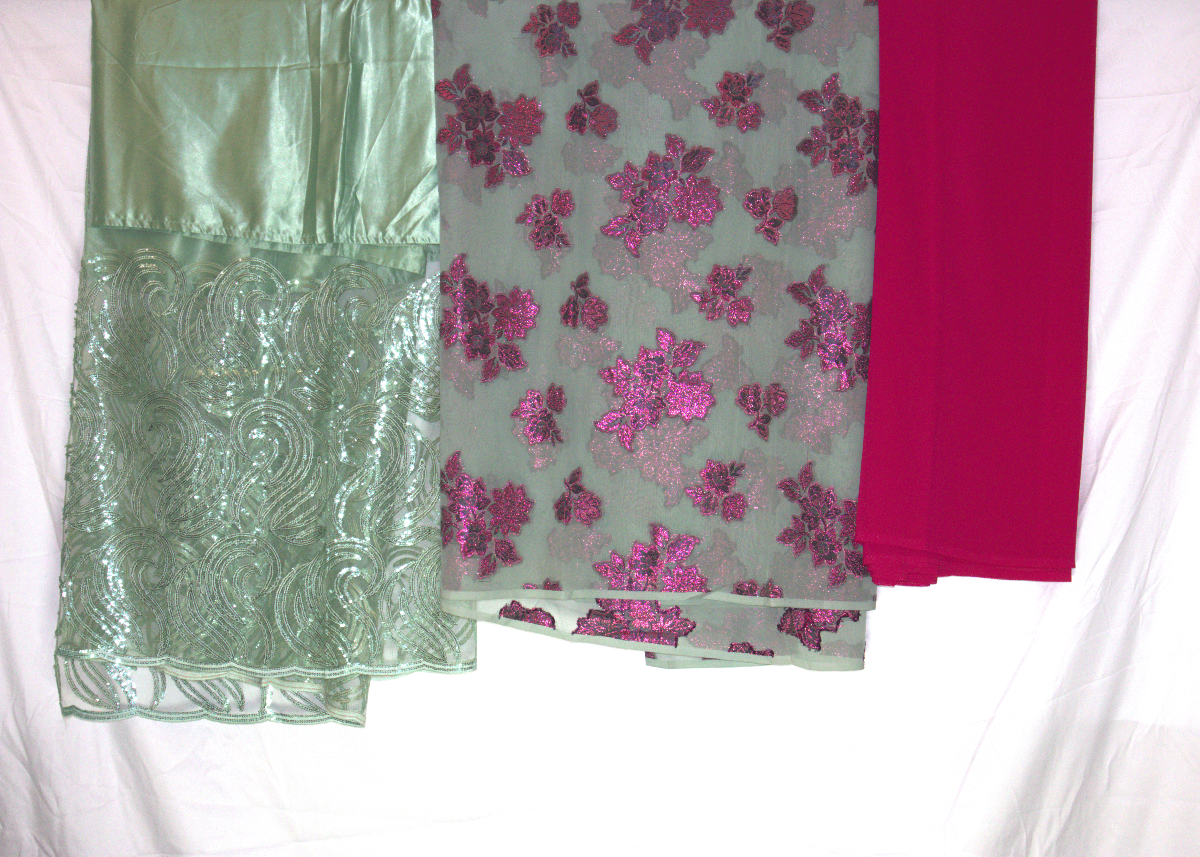 Three Somali fabric samples in green, pink floral, and pink solid on a white background