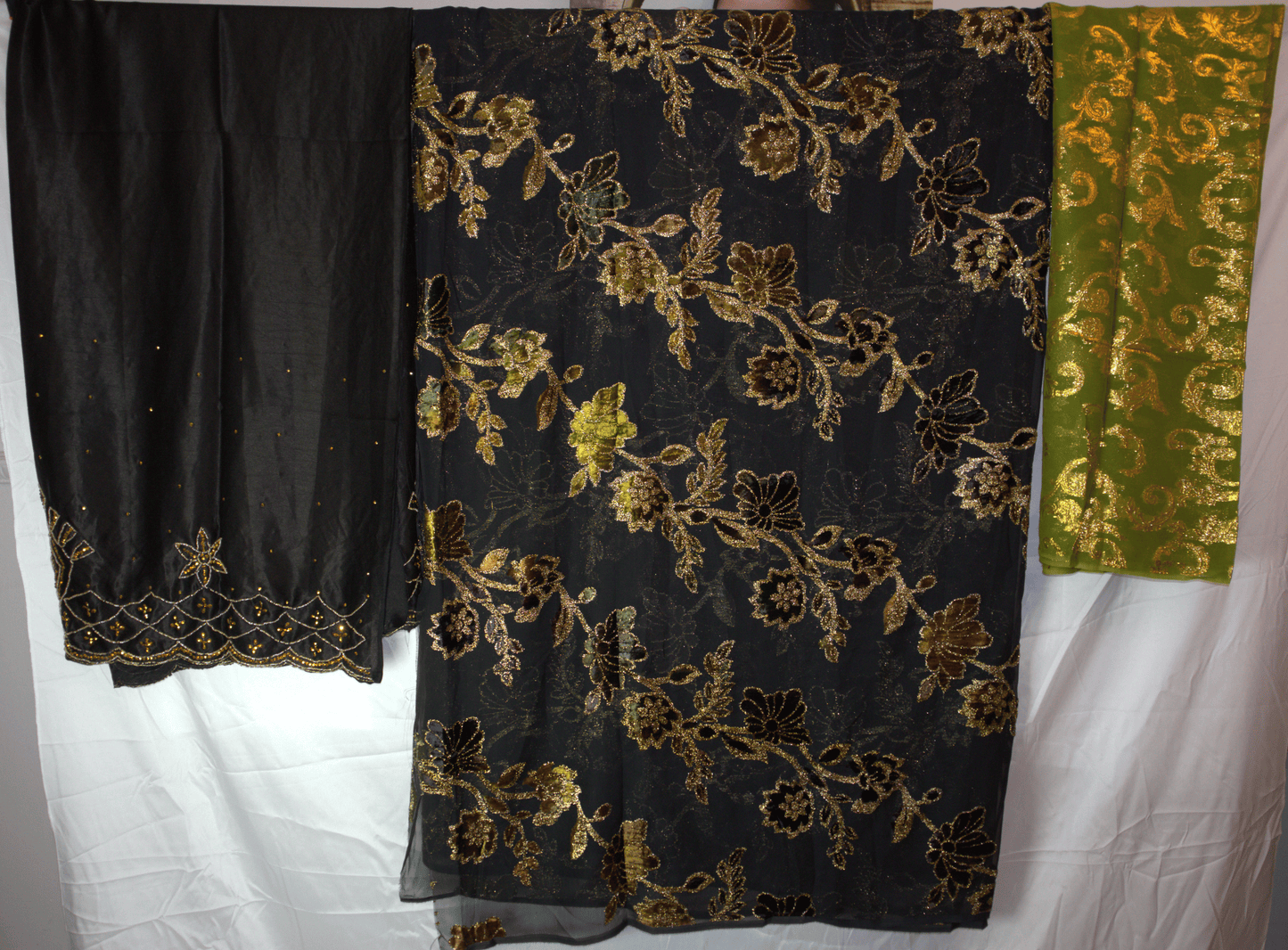 Dirac Black fabric with gold floral embroidery on a white background