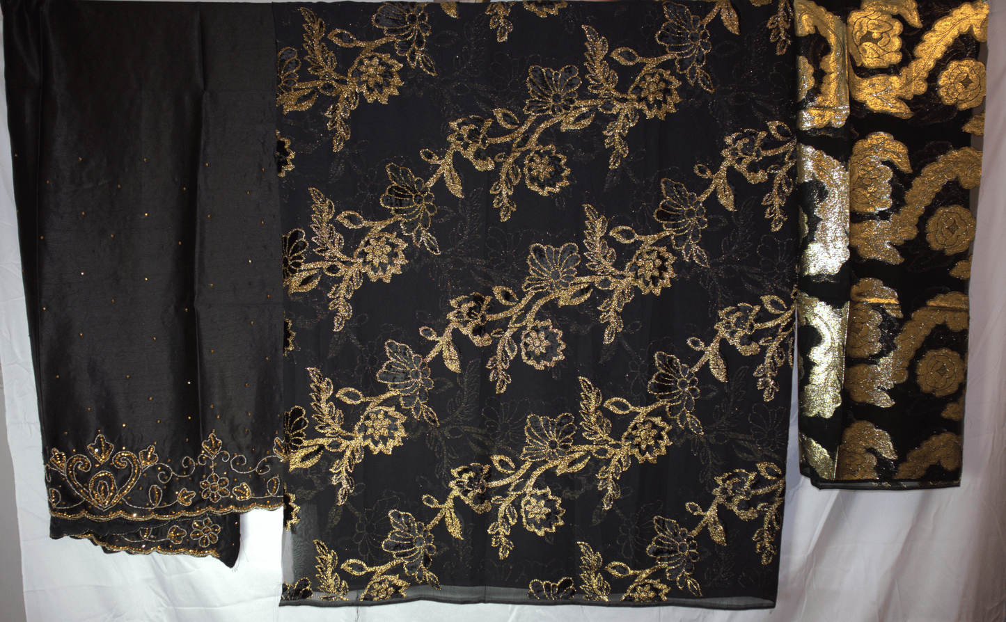 Dirac - Black fabric with gold floral embroidery on a white background