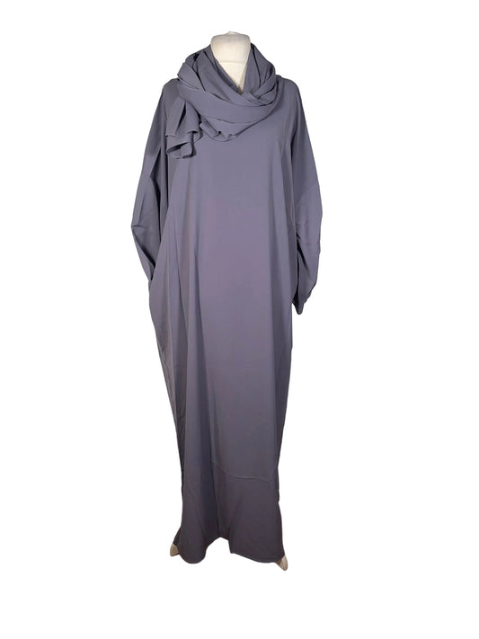 Gray dress on a mannequin against a white backdrop with wooden floor.