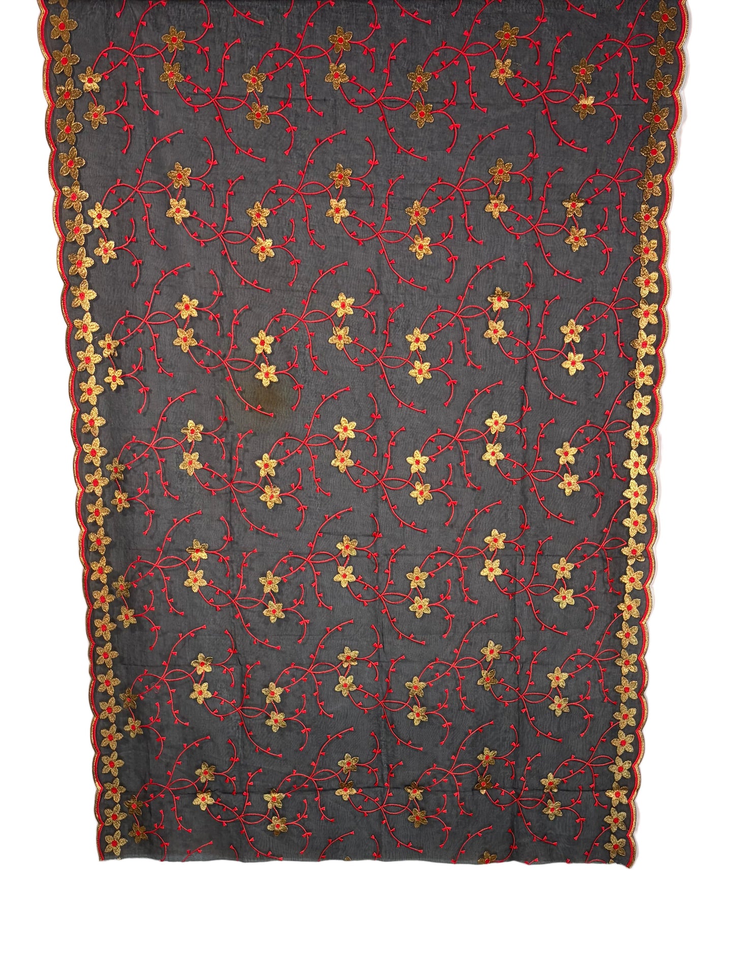 Floral-patterned fabric draped over a white quilt on a wooden surface