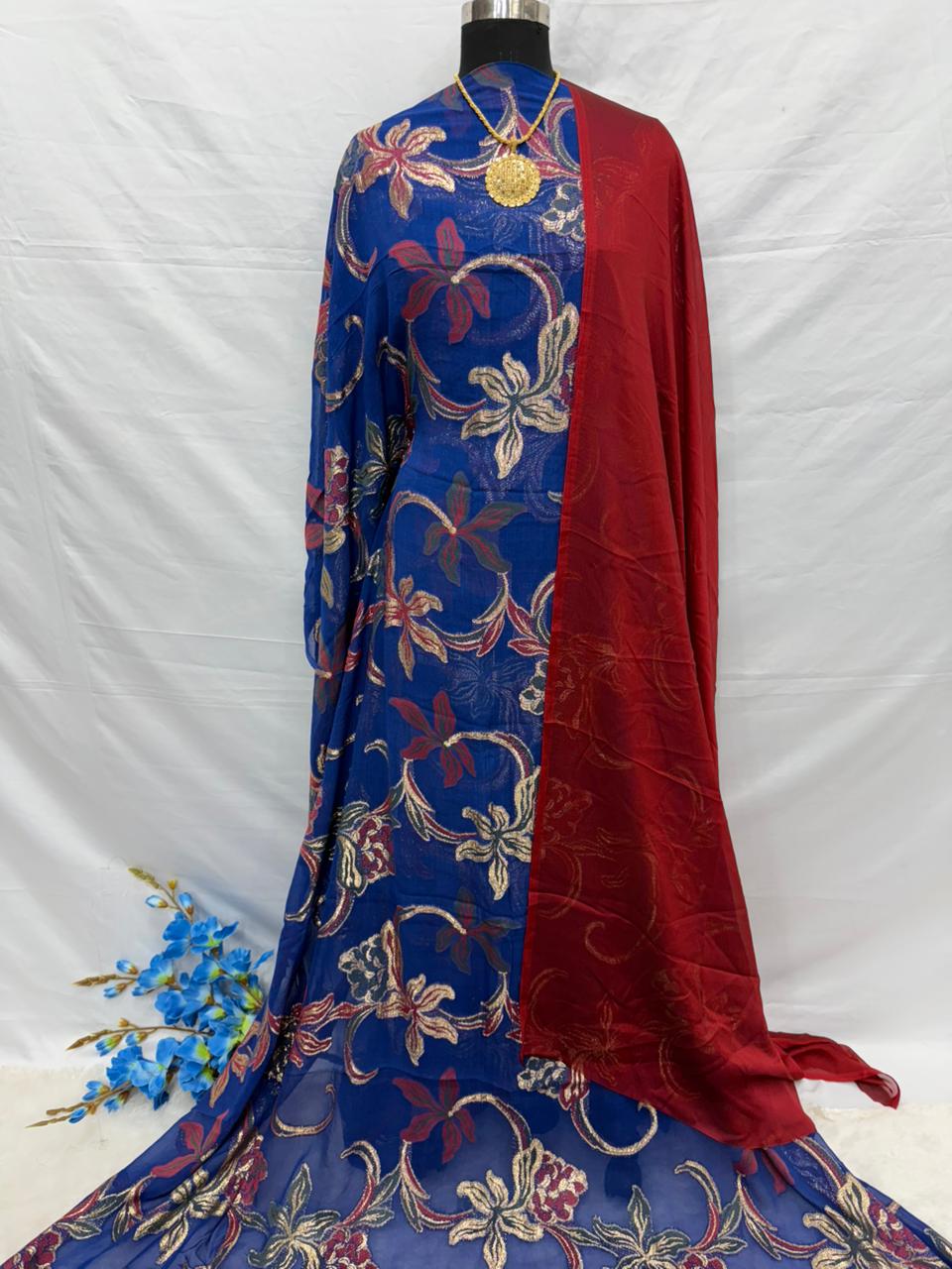Blue and red Somali Dirac embroidered fabric on a mannequin against a white background