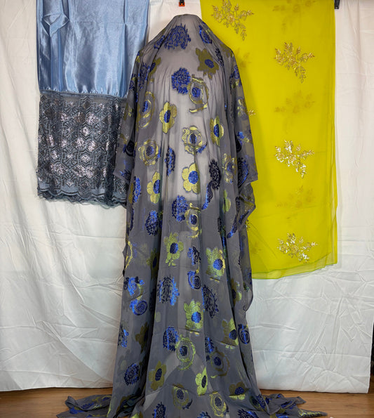 Floral-patterned fabric draped over a surface with other fabrics in the background.