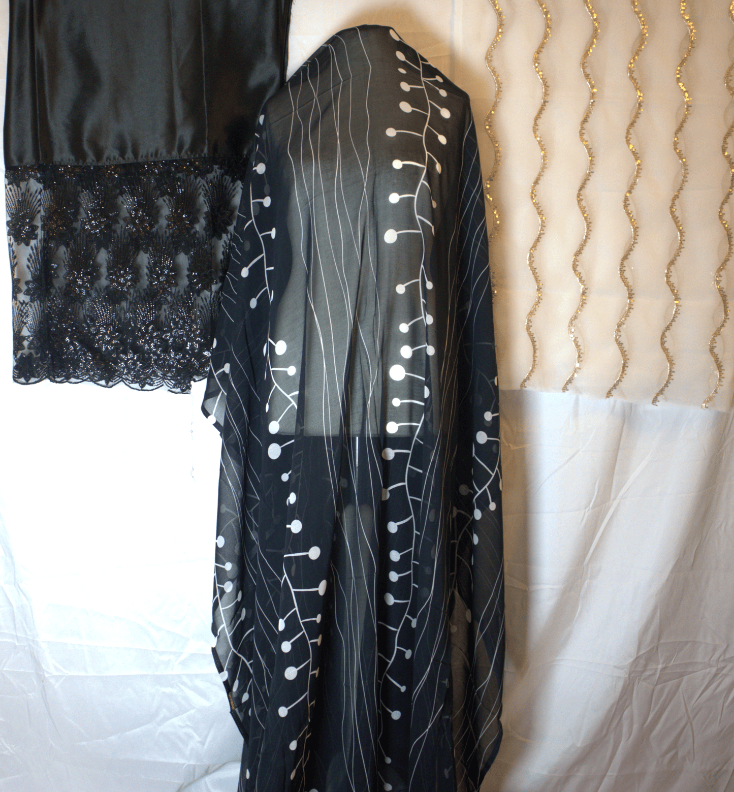 Black Somali Dirac with white patterns on a mannequin with White & gold gabsaar