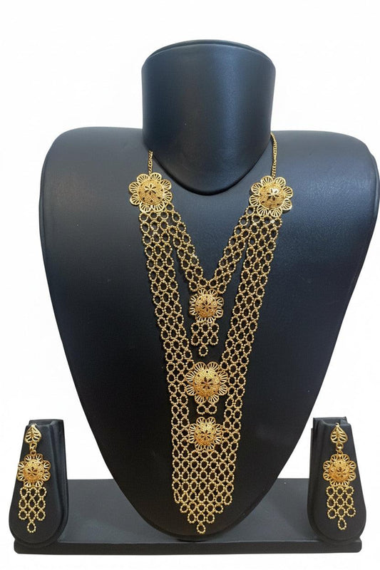 Gold-toned traditional jewelry set displayed on a black mannequin bust, including a layered necklace, matching earrings, and a small stand, against a plain white background.
