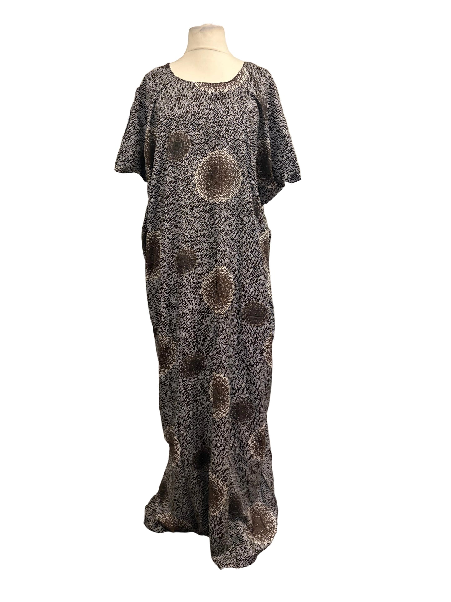 Long gray dress with circular patterns on a mannequin against a white backdrop.