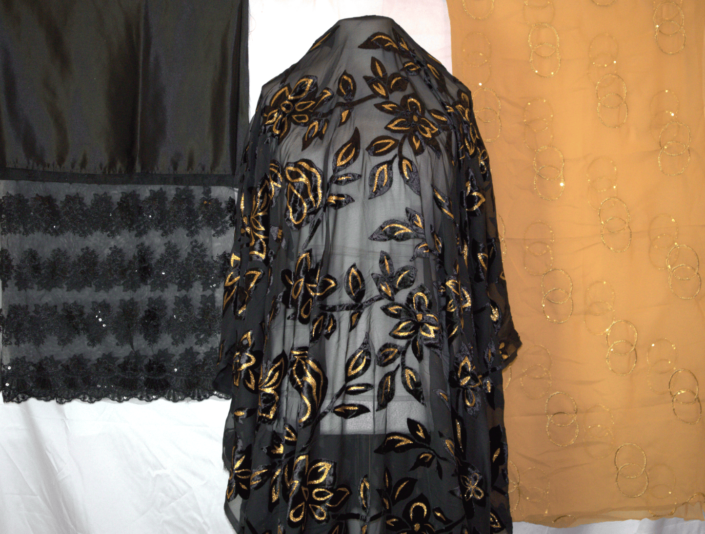 Black Maqbal Dirac with gold floral embroidery on a white background