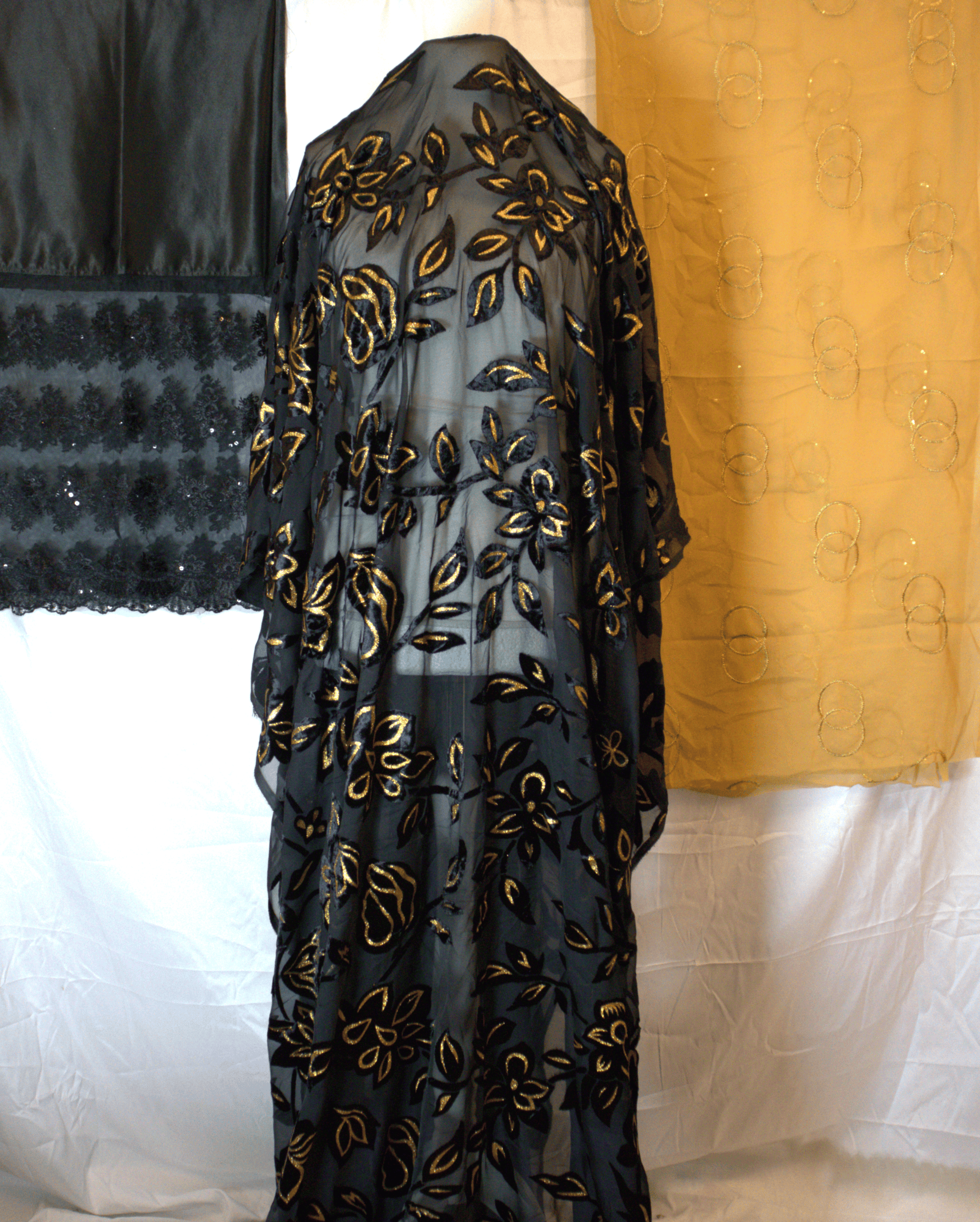 Black Maqbal Dirac with gold floral embroidery on a white background