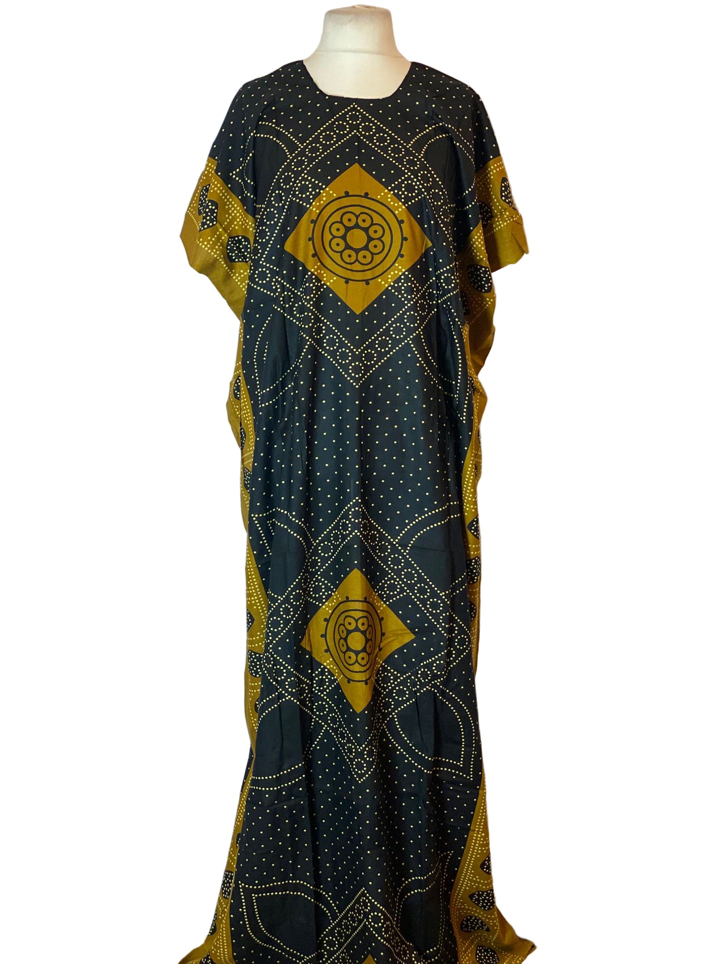 Long black Somali Baati with gold geometric patterns on a mannequin against a white background