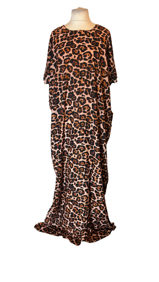 A leopard print Somali Baati dress displayed on a mannequin in front of a white fabric backdrop. The Somali Baati features a brown, black, and beige animal pattern with short wide sleeves and a loose, flowing silhouette.