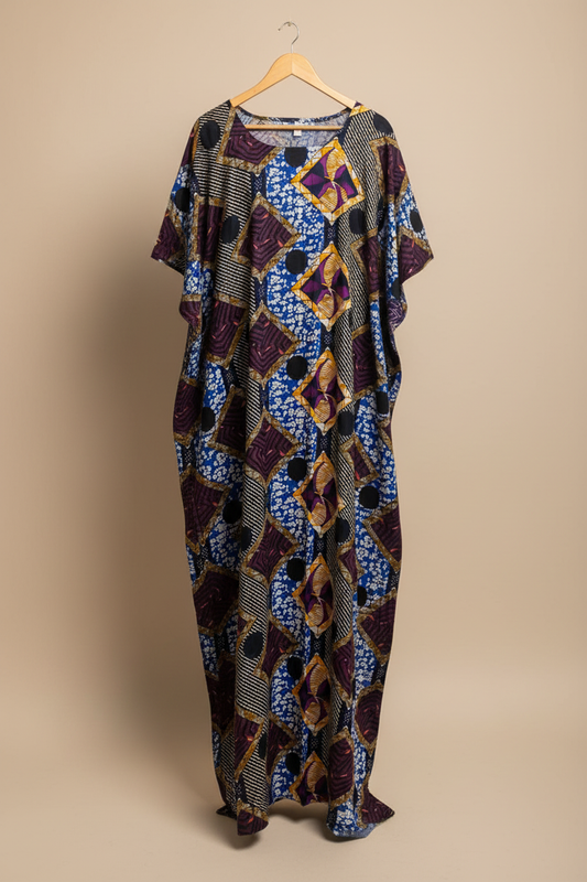 Long, patterned Somali baati dress on a hanger against a beige background