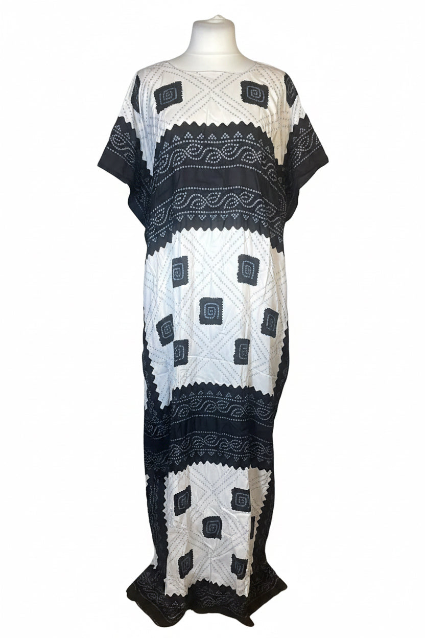 A short-sleeve bohemian-style maxi dress with a black and white geometric pattern, displayed on a white mannequin torso against a white background.