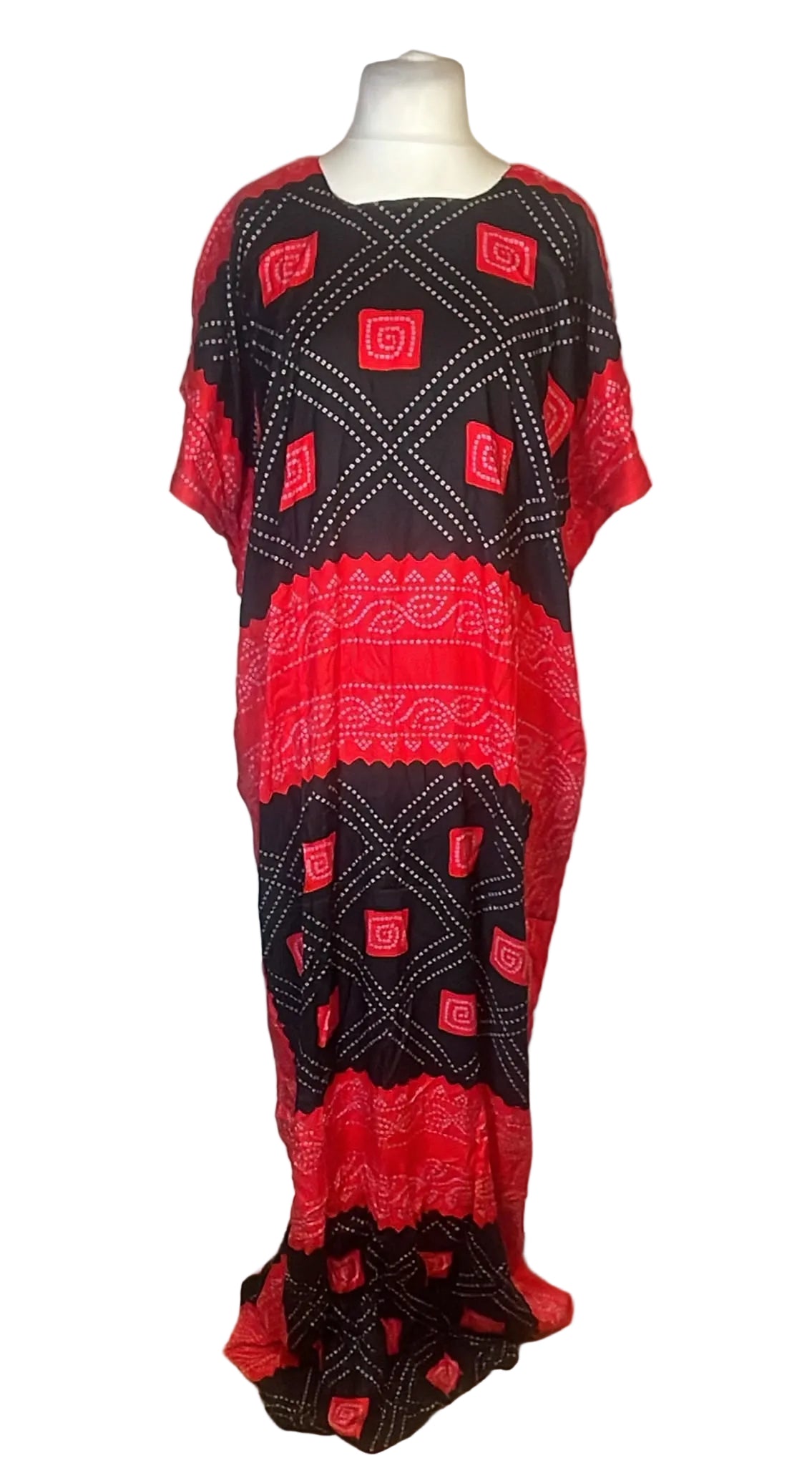 A short-sleeved kaftan dress with a black and red geometric block print pattern, displayed on a mannequin against a white fabric backdrop.