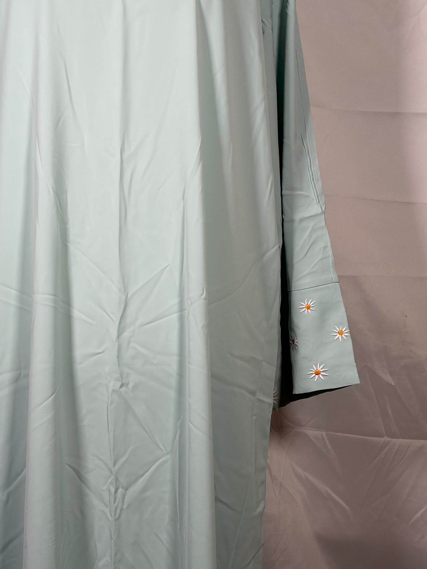 Light gray Abaya with floral embroidery on a plain background