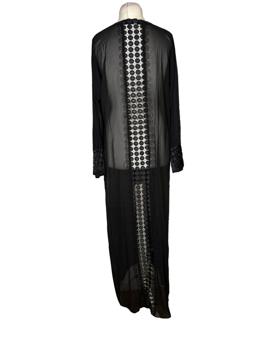 Black dress with intricate white patterns on a mannequin against a white backdrop