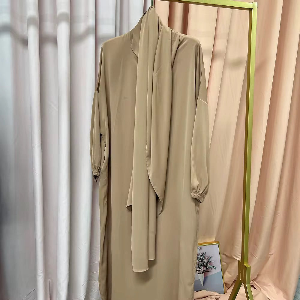 Beige dress hanging on a rack against a neutral background