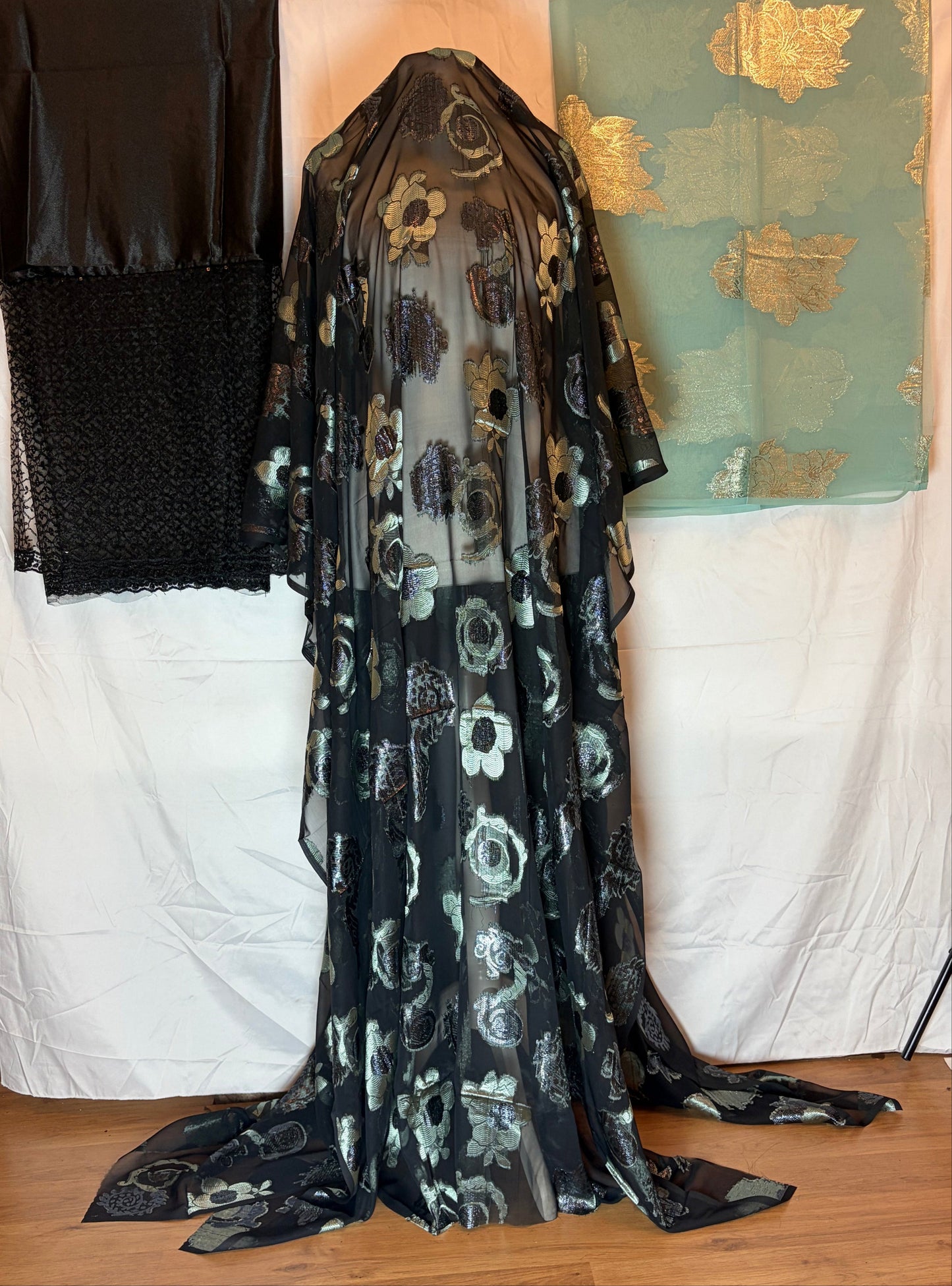 Black patterned fabric on a bed with a green box in the background