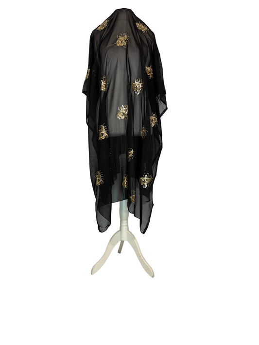 Black sheer fabric with gold embroidery on a white surface