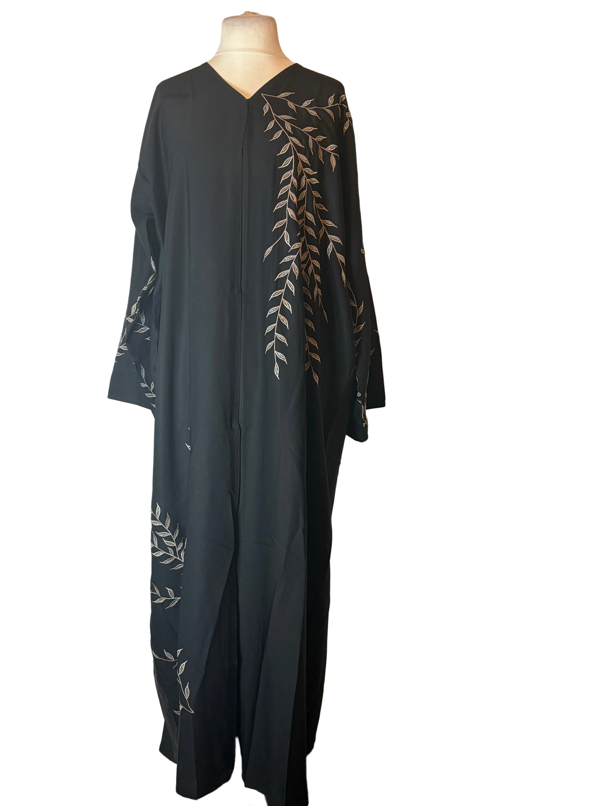 Black abaya with white floral embroidery on a mannequin against a white backdrop