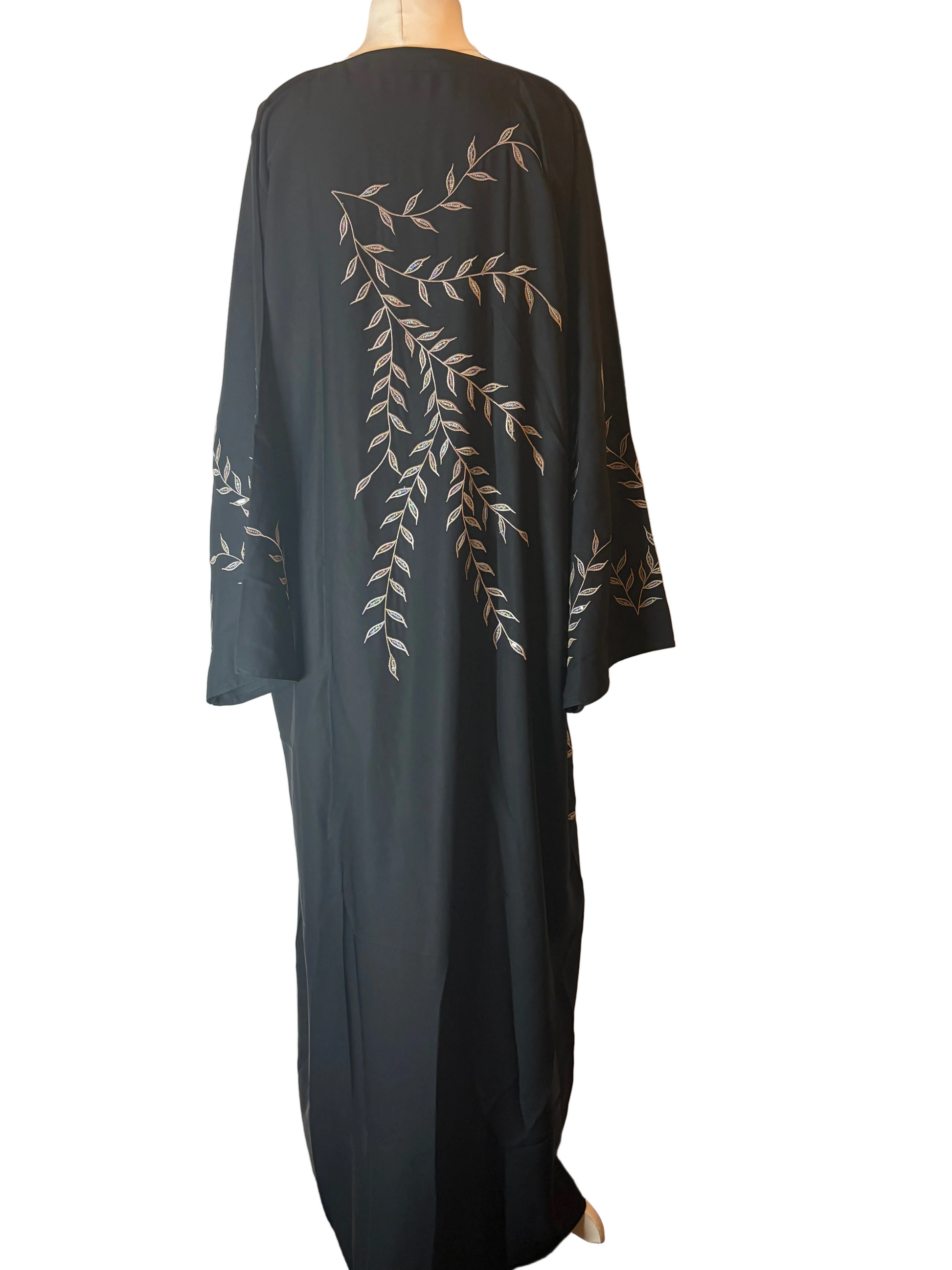 Black abaya with gold leaf patterns on a white background