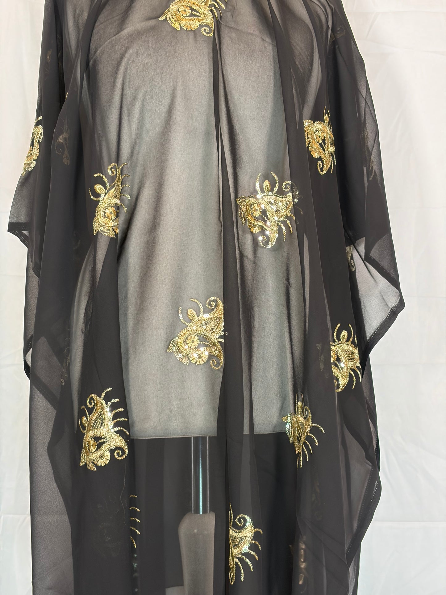 Black fabric with gold embroidery on a white background