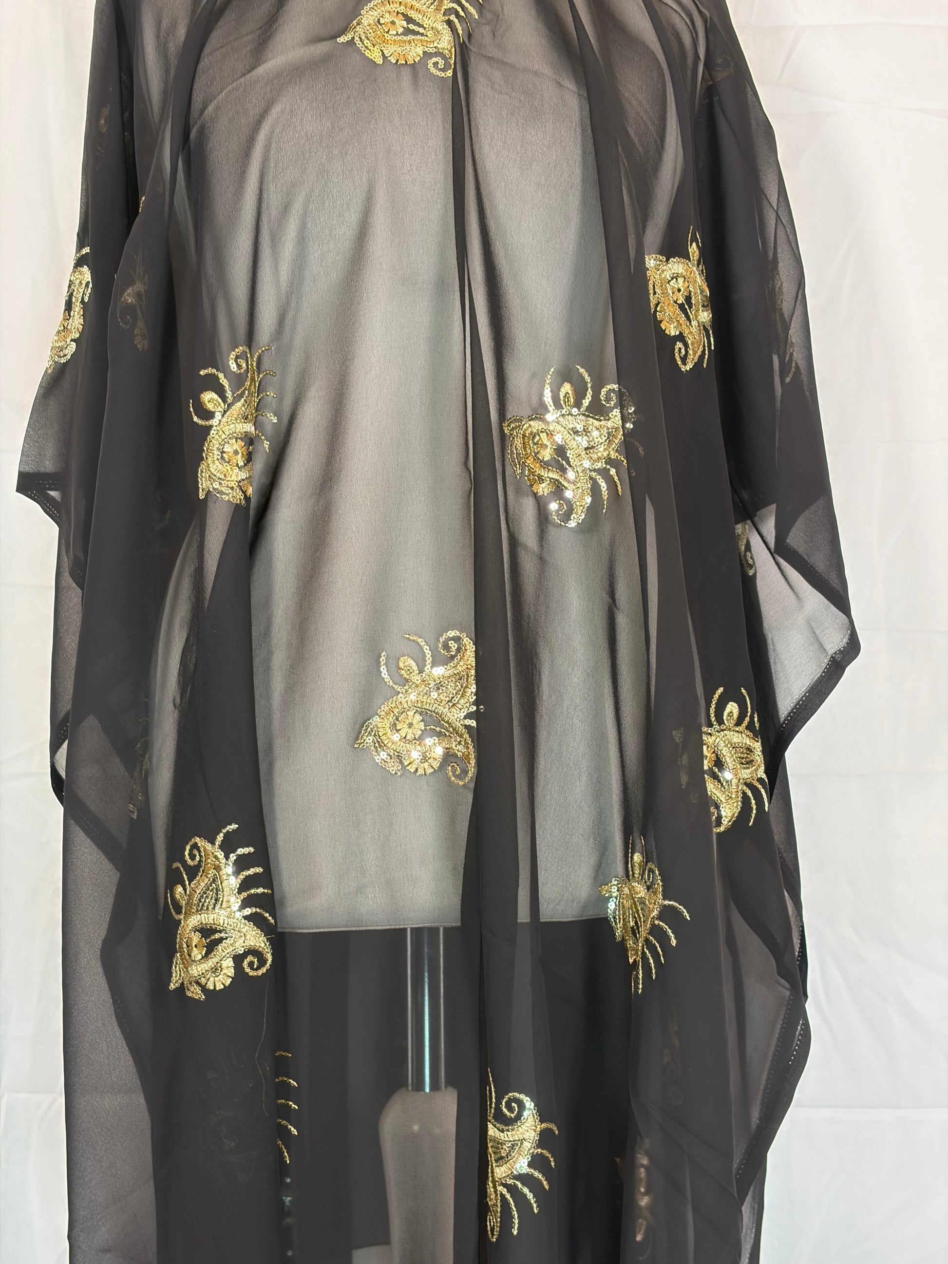 Black fabric with gold embroidery on a white background