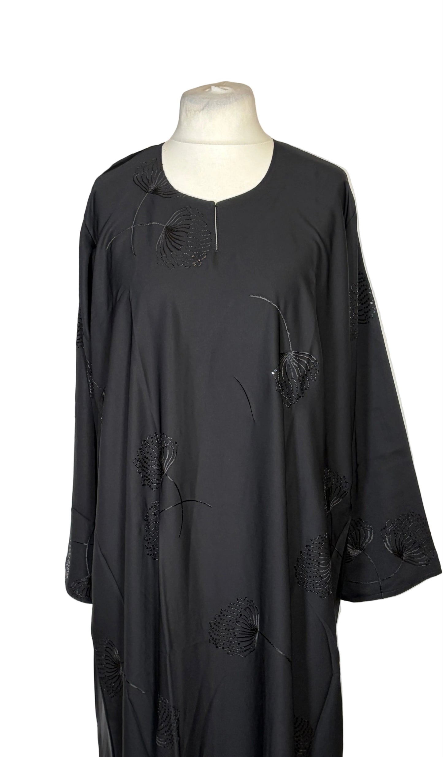 Black one piece abaya on a mannequin against a white background