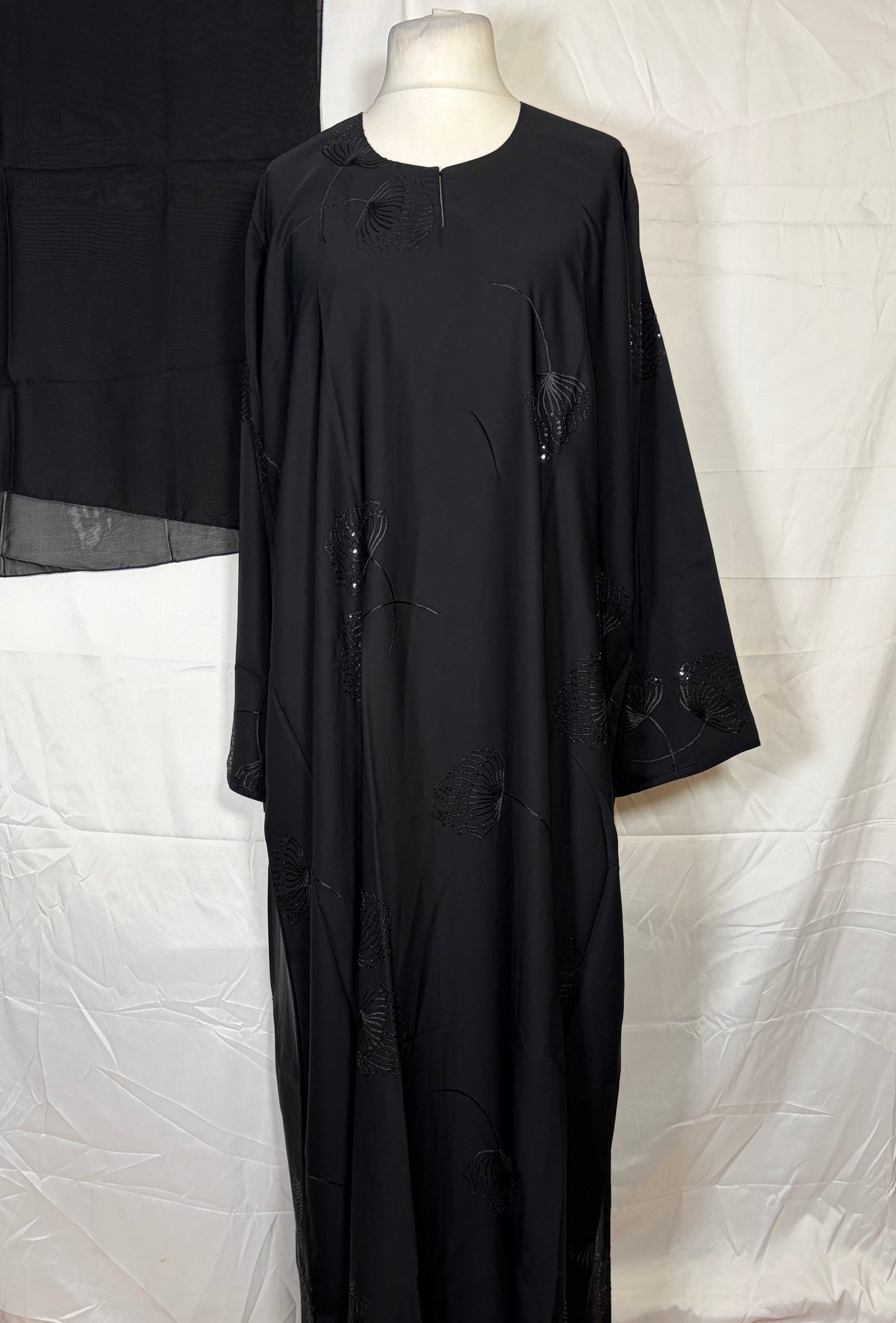Black one piece abya on a mannequin against a white background