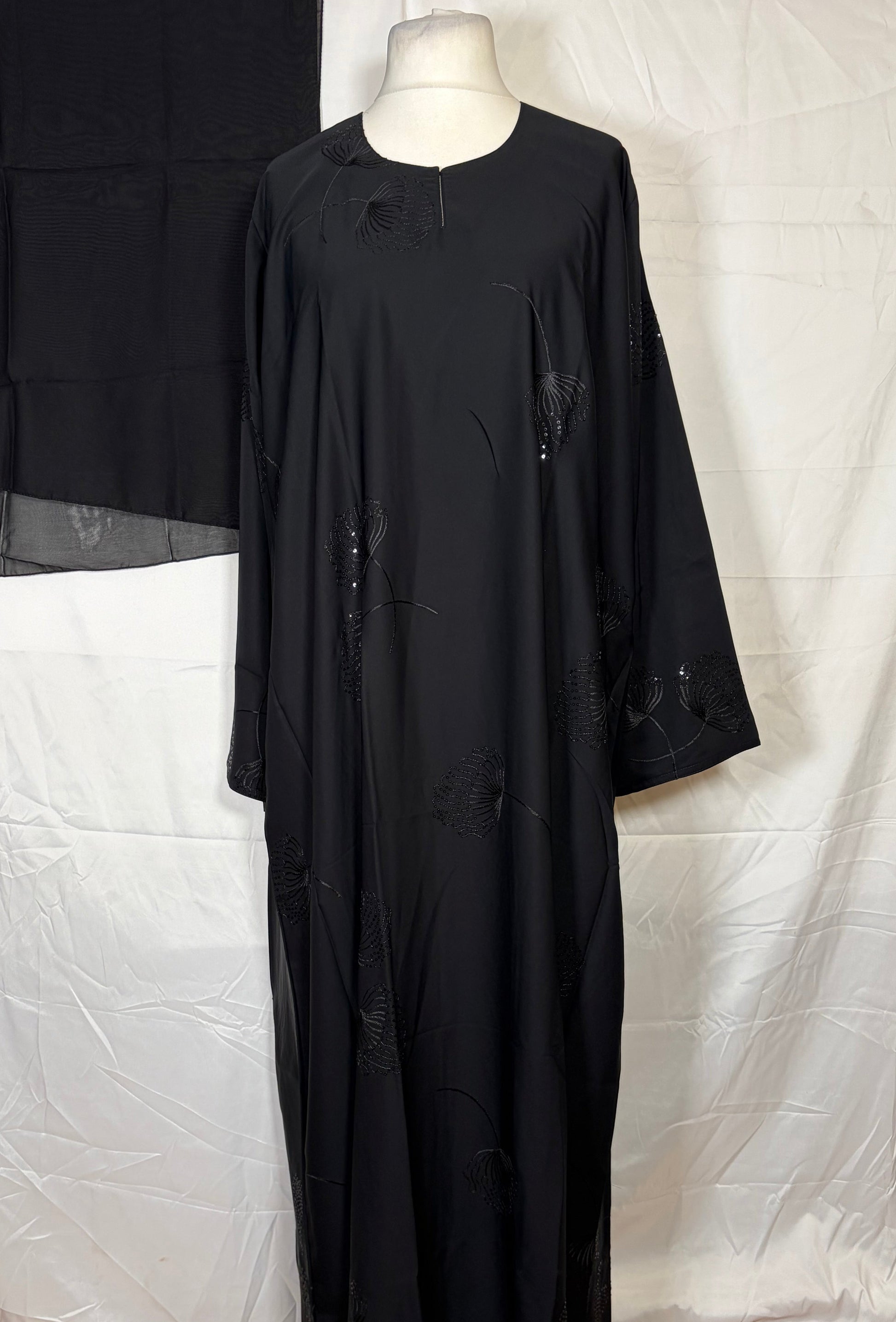 Black one piece abya on a mannequin against a white background