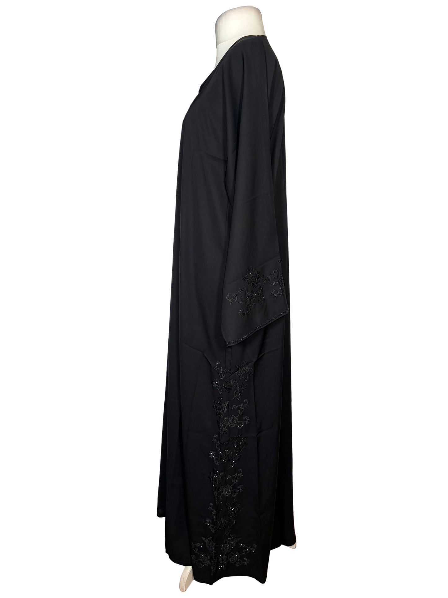 Black Abaya dress with embroidery detailing on a white surface