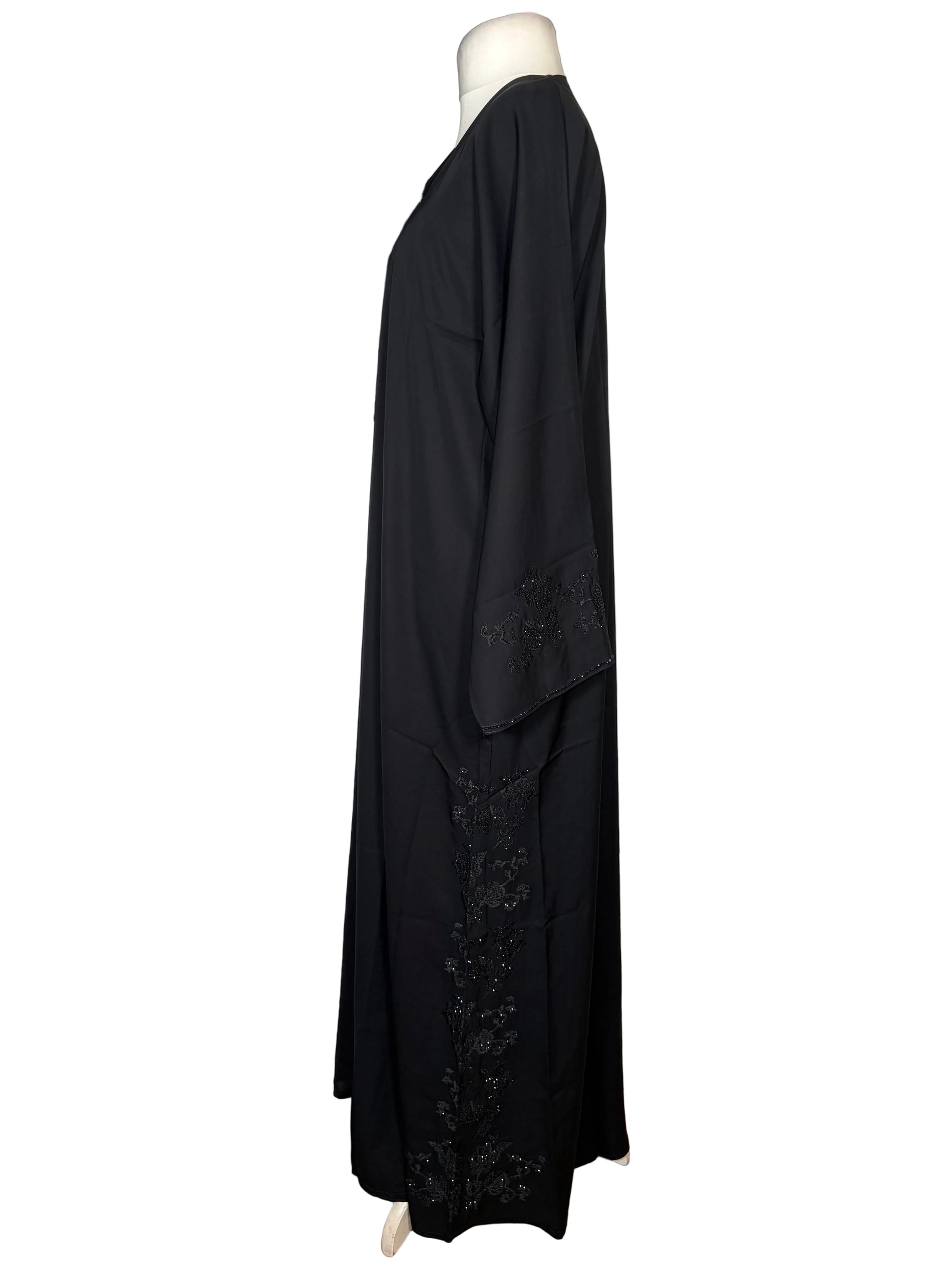 Black Abaya dress with embroidery detailing on a white surface