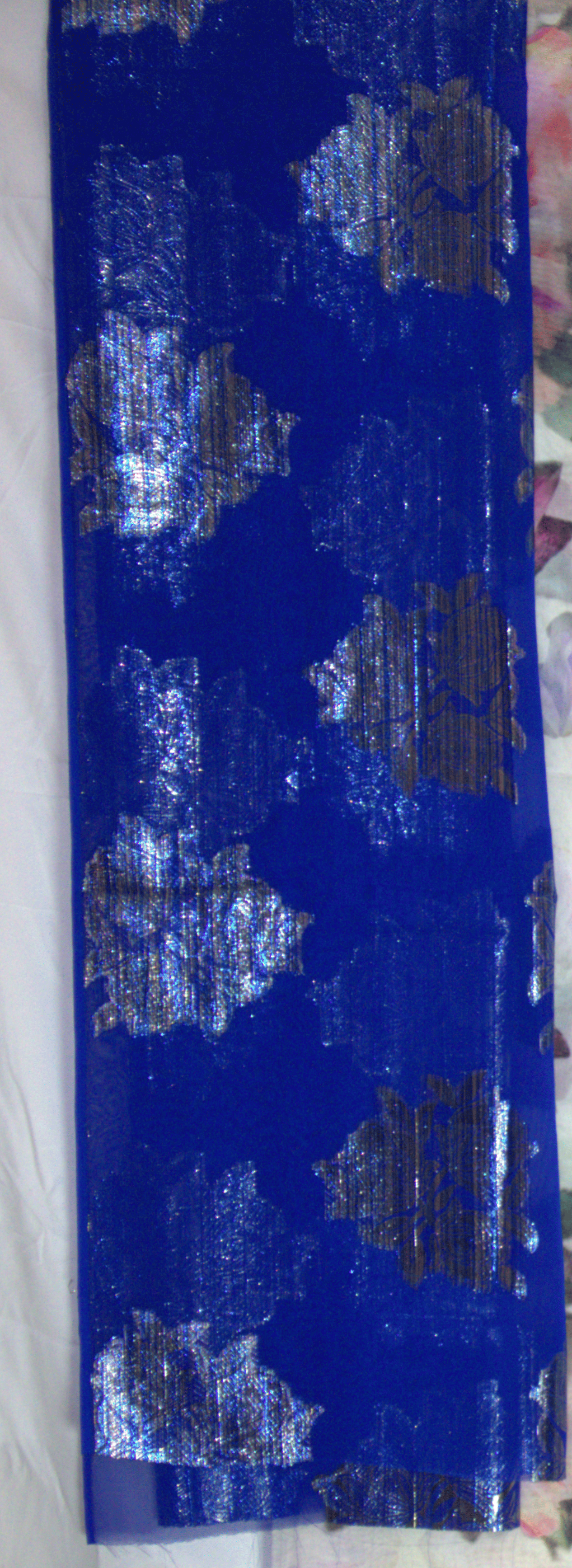 Blue Garbasaar fabric with silver geometric patterns on a white background