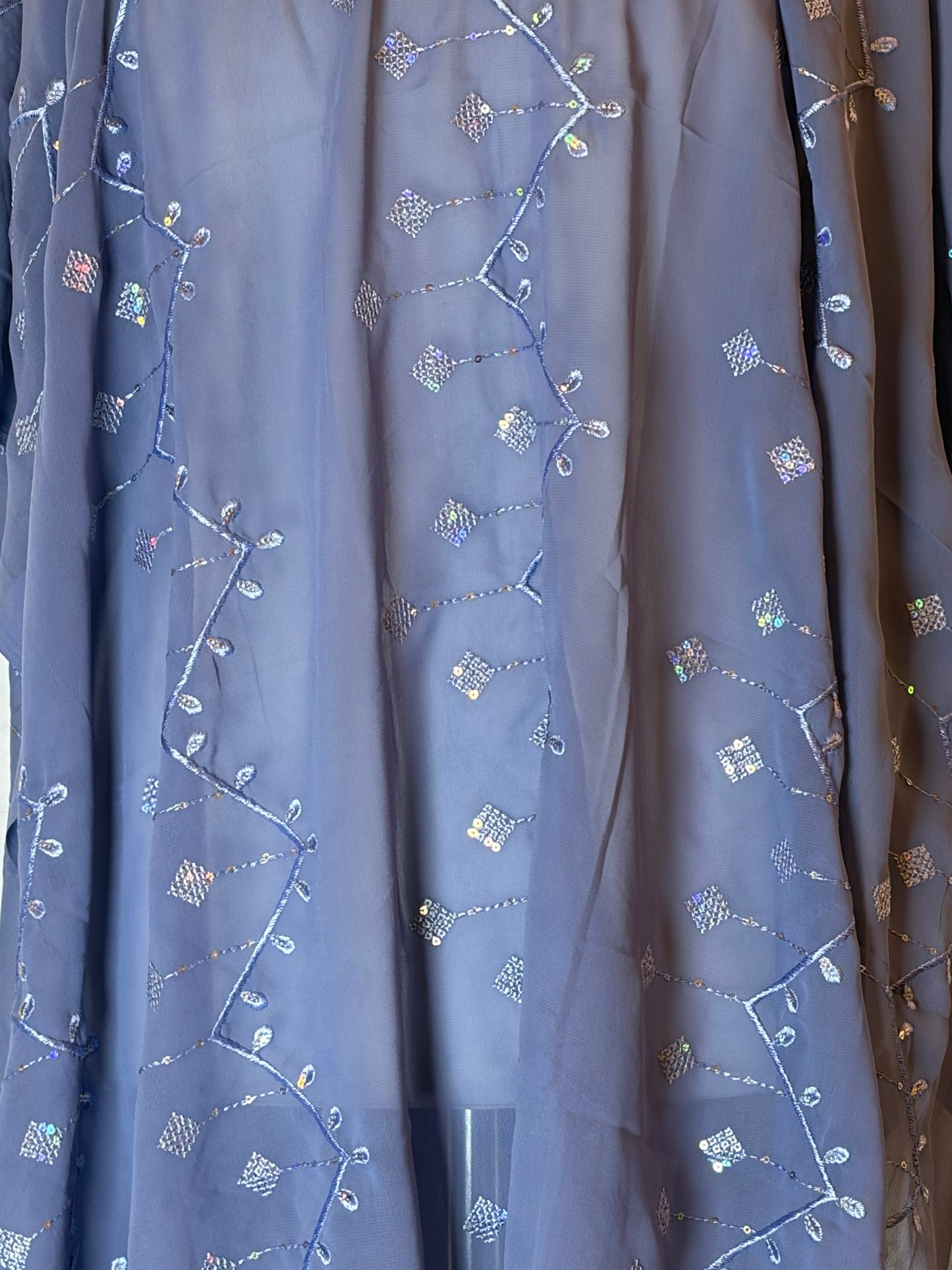 Embroidered Garbasaar fabric with floral patterns on a blue background