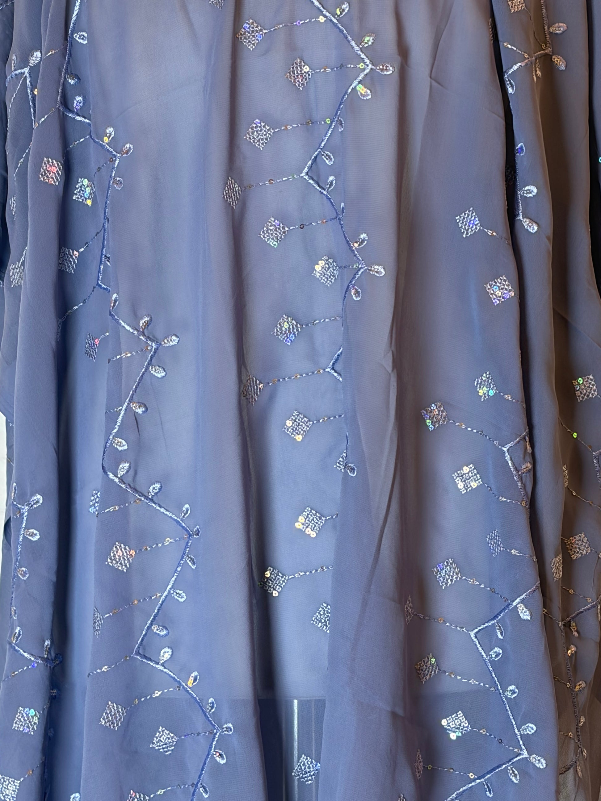 Embroidered Garbasaar fabric with floral patterns on a blue background