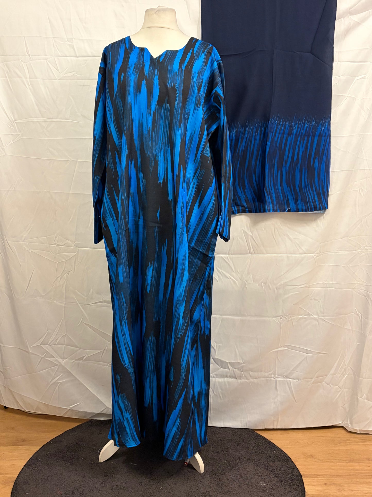 Blue and black patterned dress on a mannequin against a white backdrop