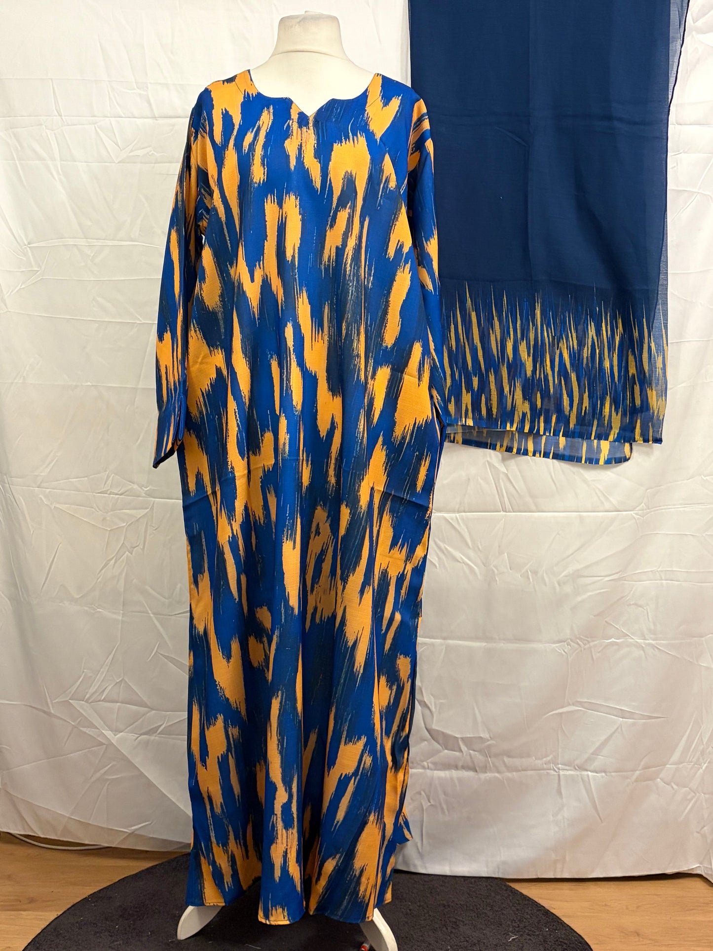 Blue and yellow patterned dress on a mannequin against a white background