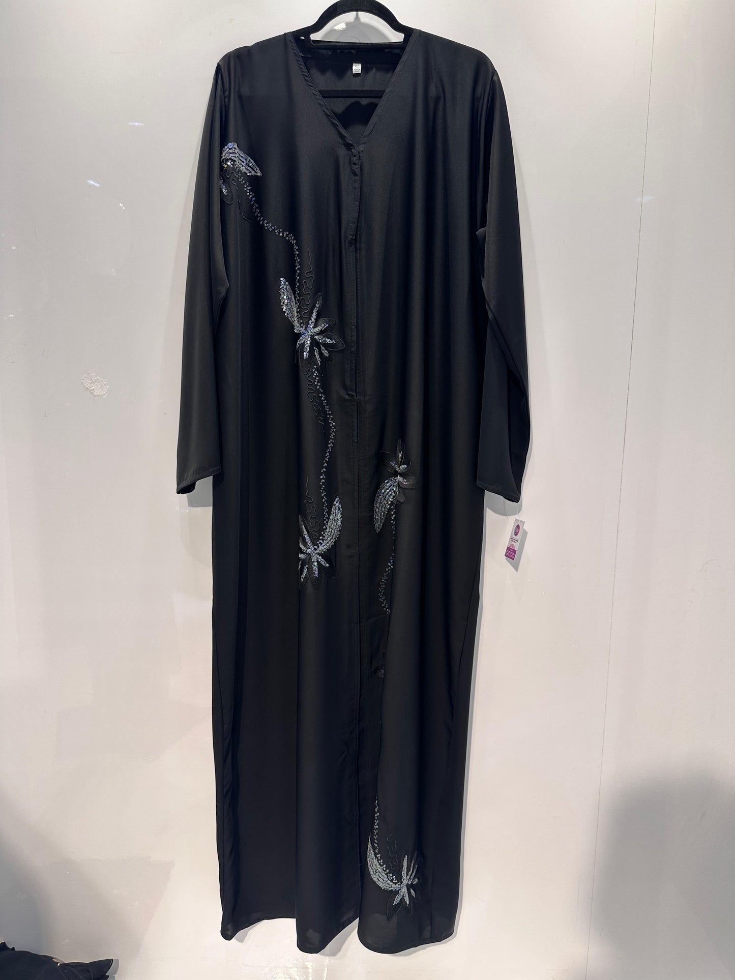 Black dress with silver embroidery on a white background