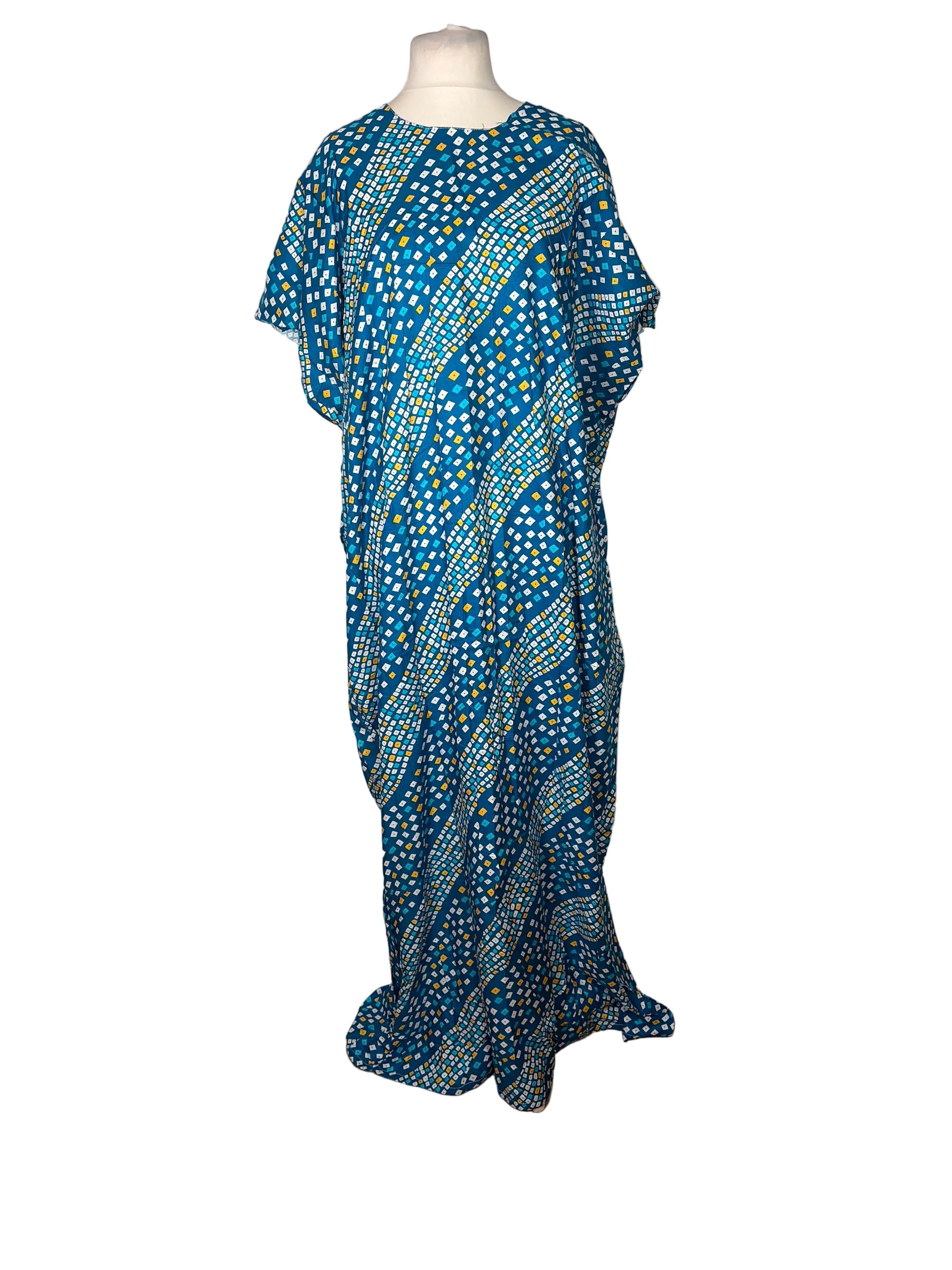 Blue patterned dress on a mannequin against a white curtain background