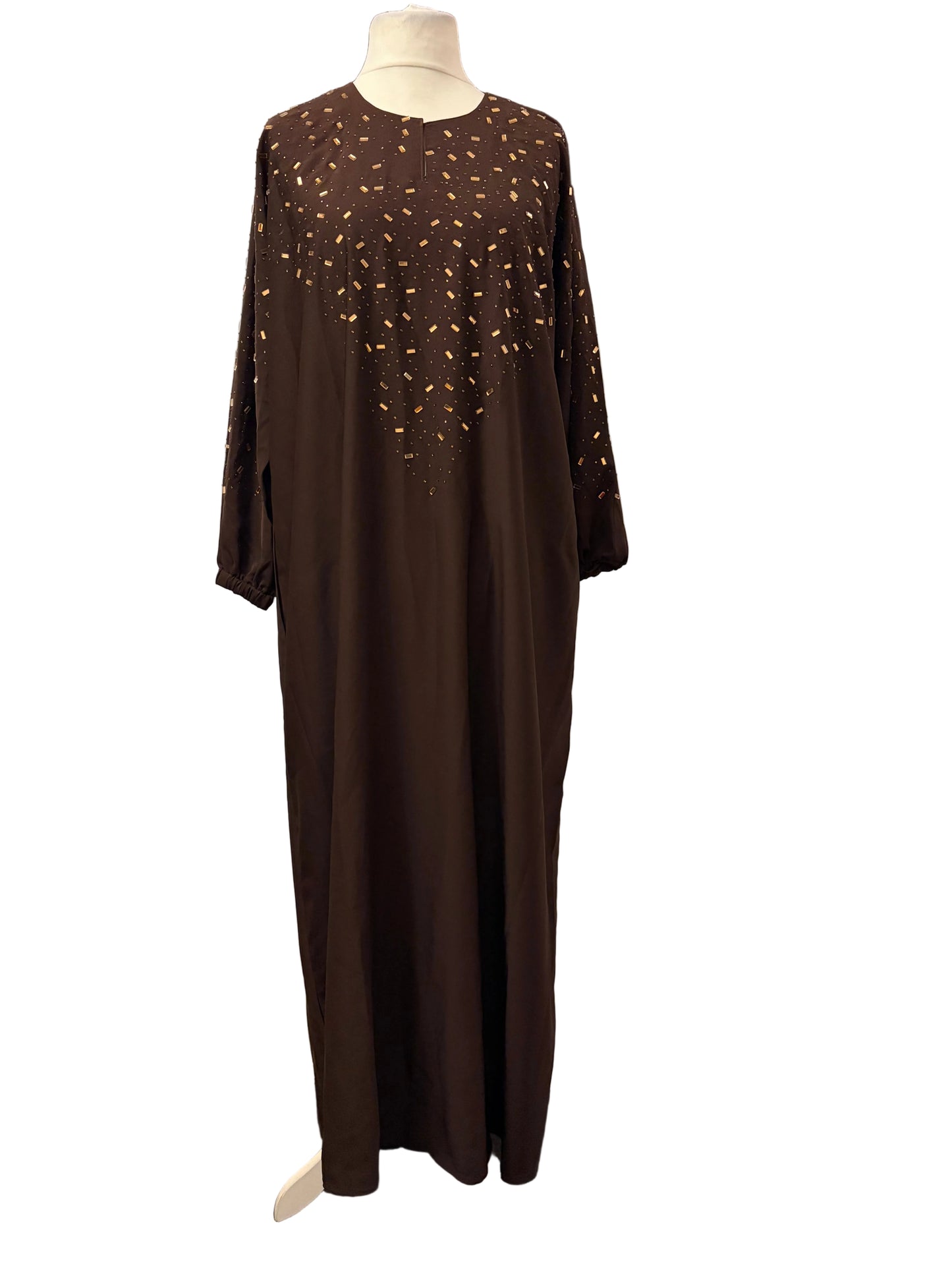 Brown dress with intricate detailing on a mannequin against a white backdrop