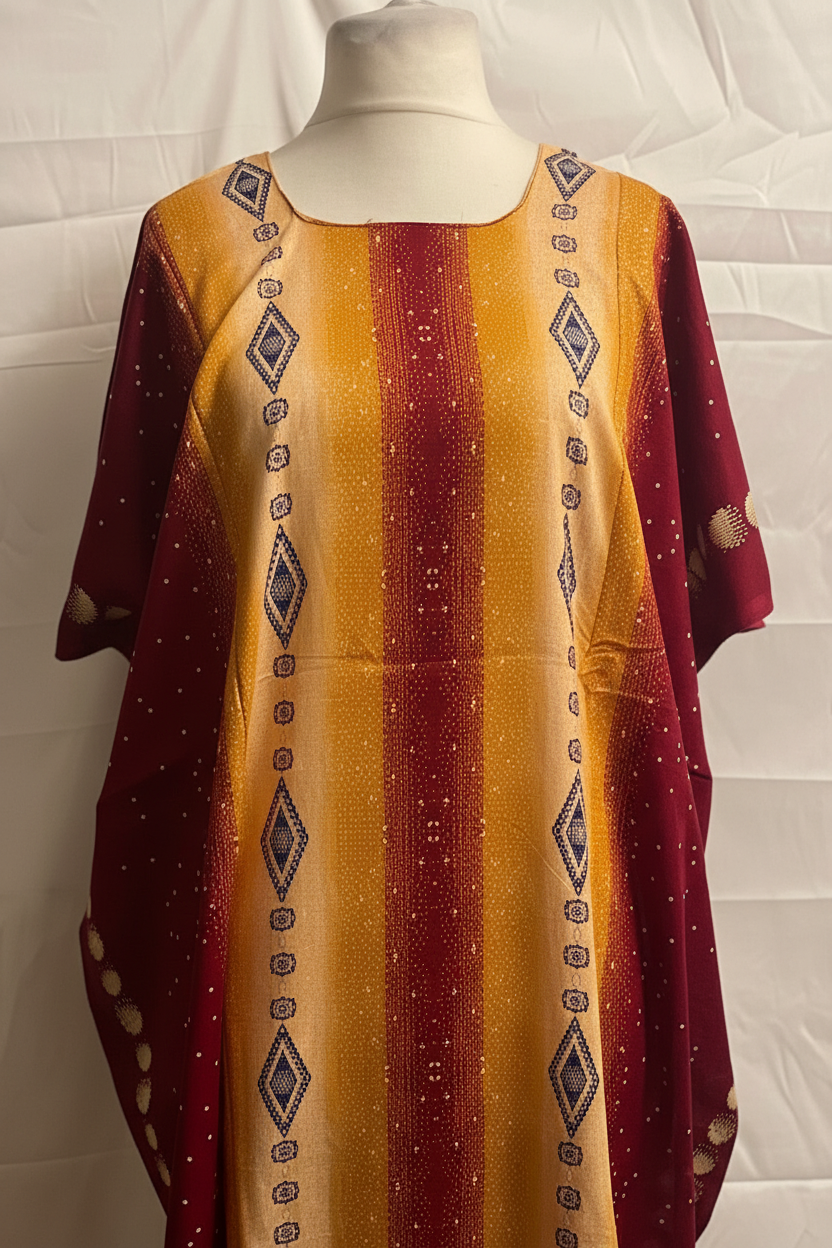 Yellow and red patterned Somali baati on a mannequin against a white background