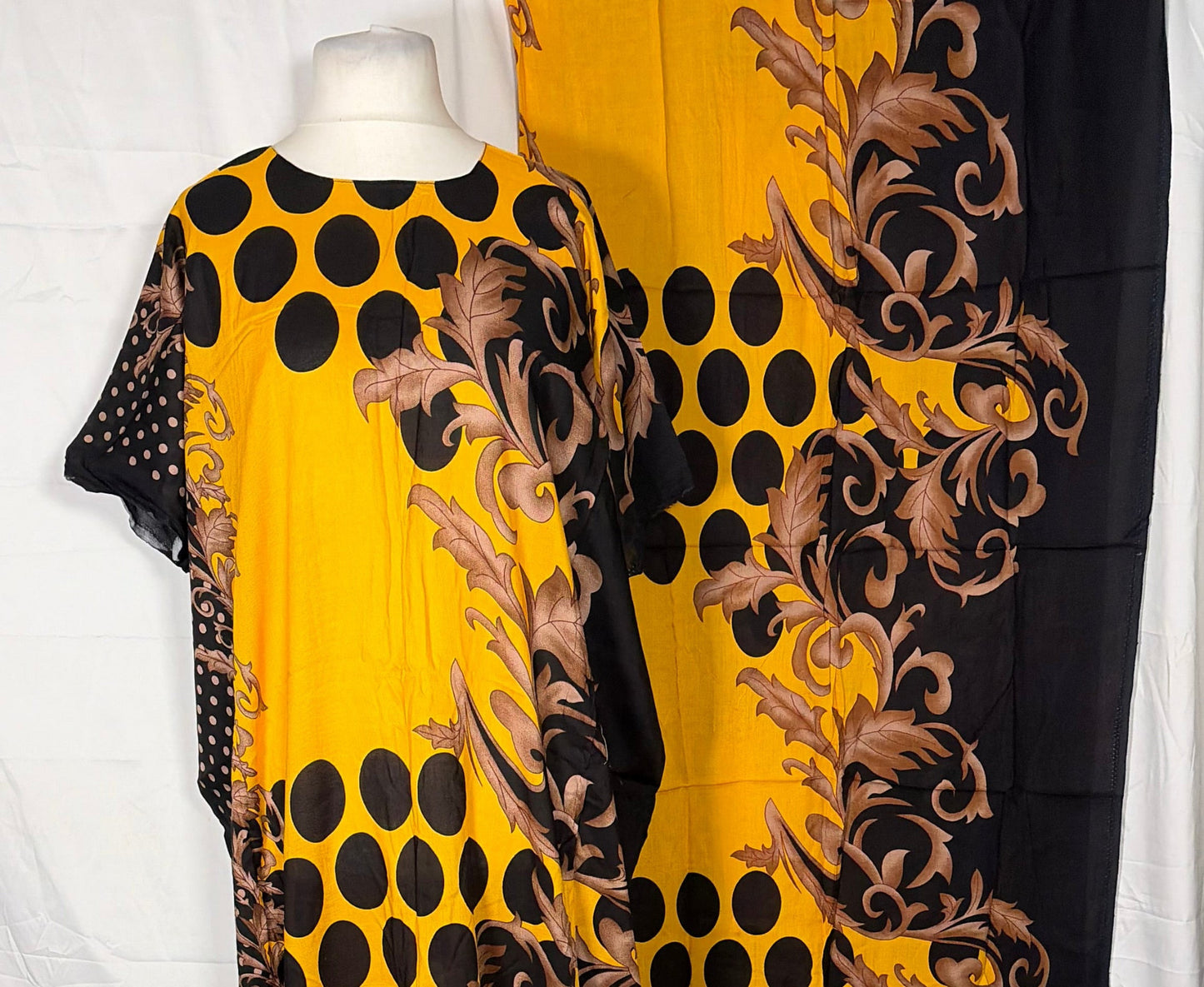 Yellow dress with black polka dots and brown floral patterns on a white background