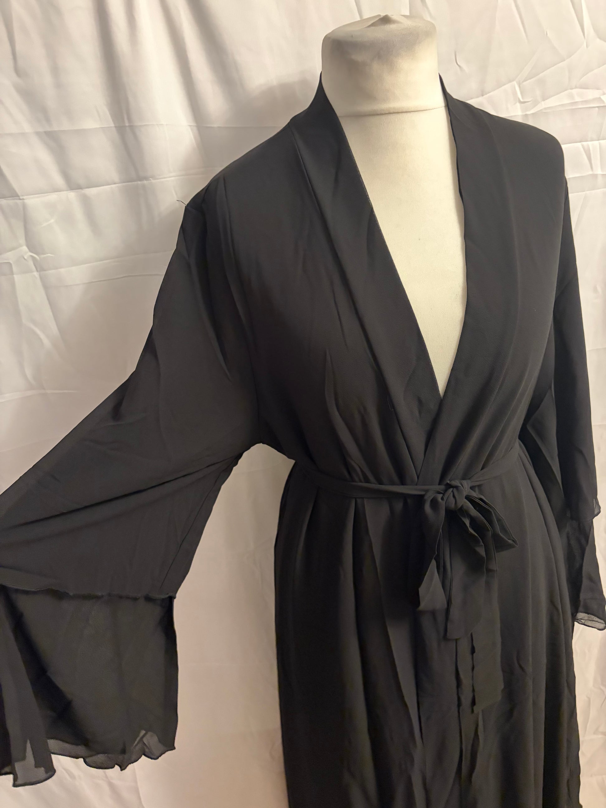 Black abaya on a mannequin against a white background