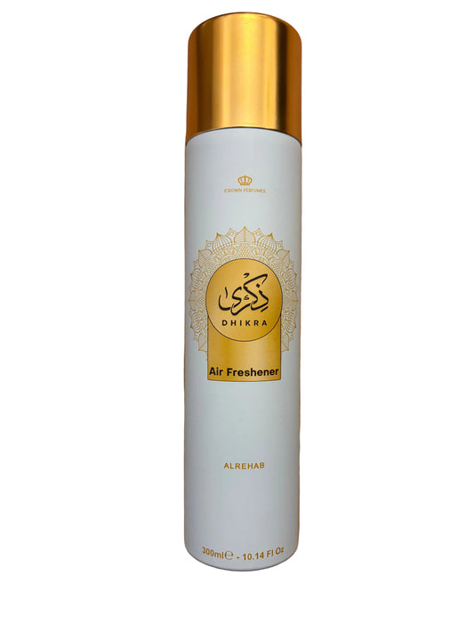 hikra Air Freshener by Al Rehman, featuring a white cylindrical body with a metallic gold cap and gold decorative graphics, placed on a wooden floor.