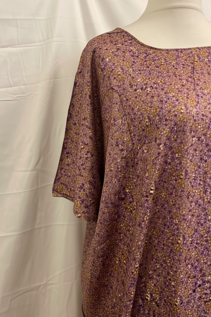 Purple floral dress on a mannequin against a white background