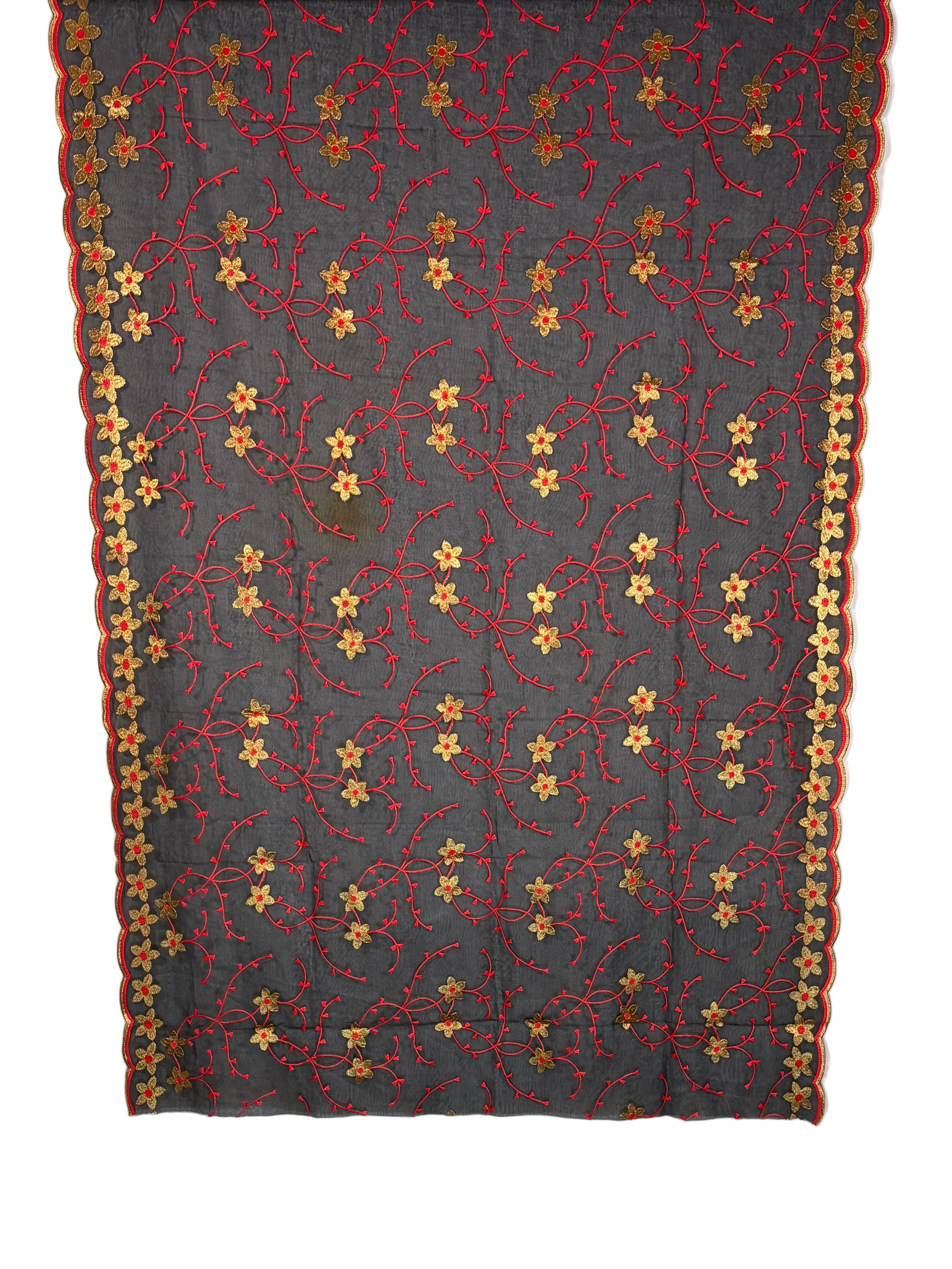 Floral-patterned fabric draped over a white quilt on a wooden surface