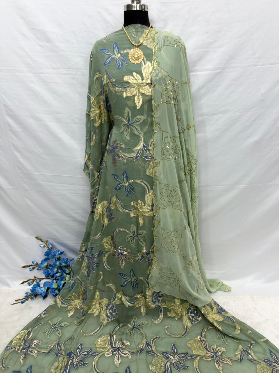 Green embroidered Somali Dirac Fabric on a mannequin with a white background