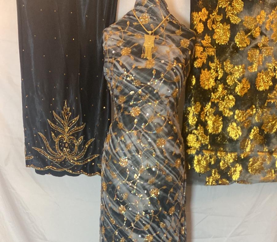 Three pieces  Dirac fabric with gold embroidery on a white background