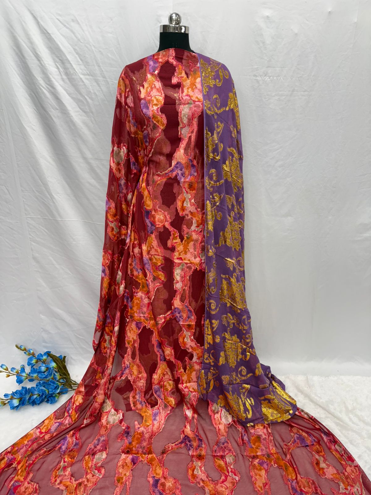 Mannequin wearing a colorful sheer fabric with floral patterns on a white background
